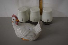 Hen on nest egg cover together with three kitchen storage jars
