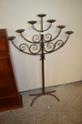 An iron floor standing seven light candelabra or menorah with spreading four footed base, 118cm