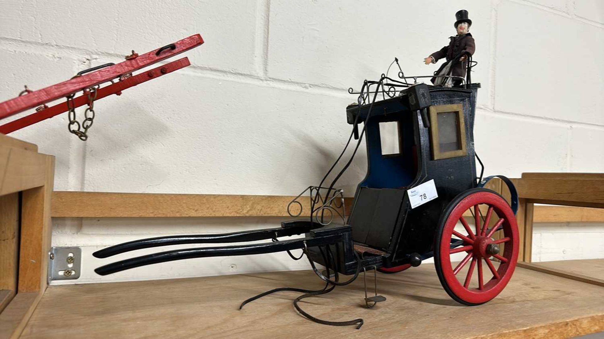 A scratch built model of a Victorian carriage painted in black with red wheels together with a