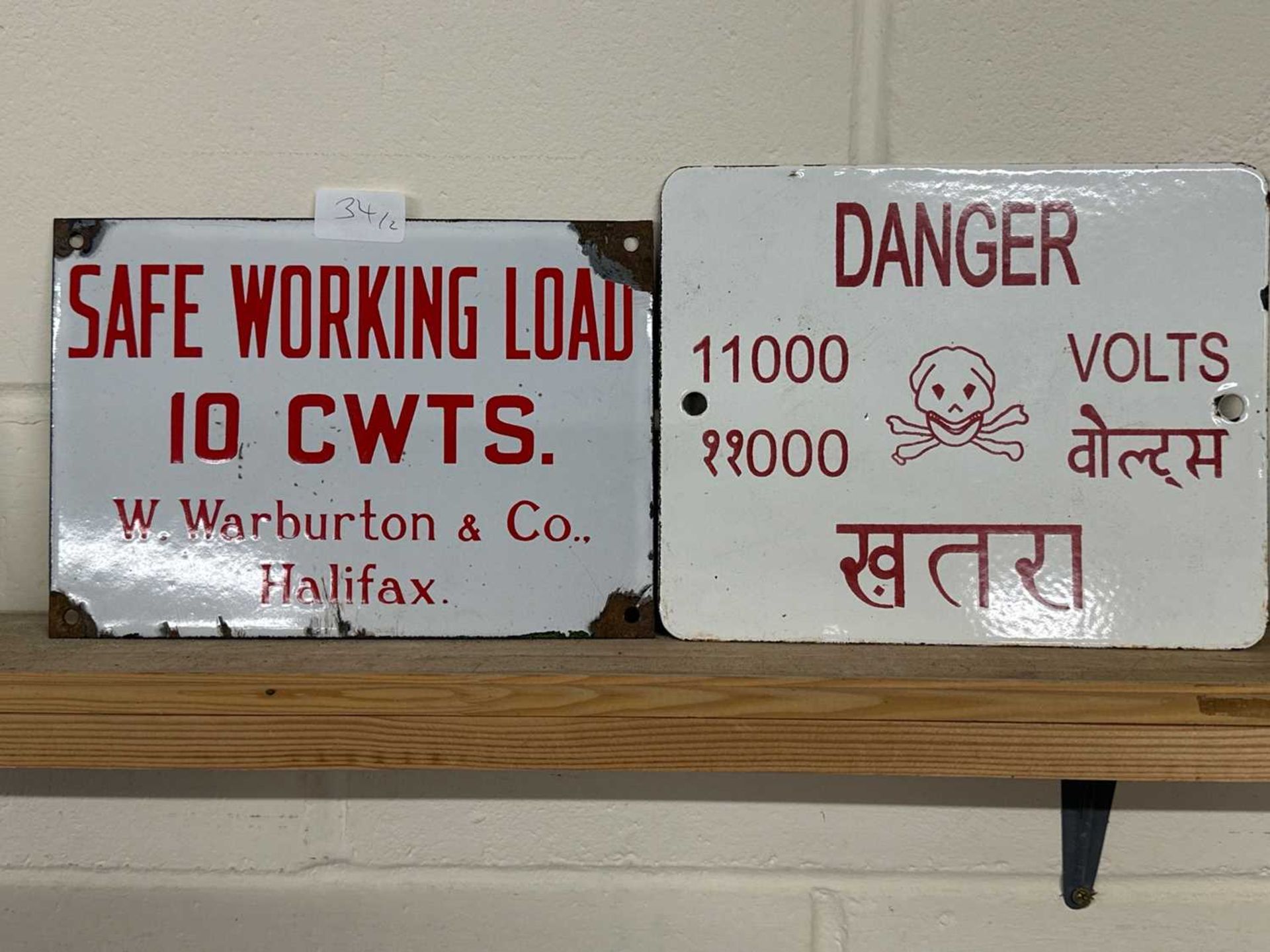 Two metal informational signs including "Safe Working Load 10cwts W Warburton & Co Halifax" and a