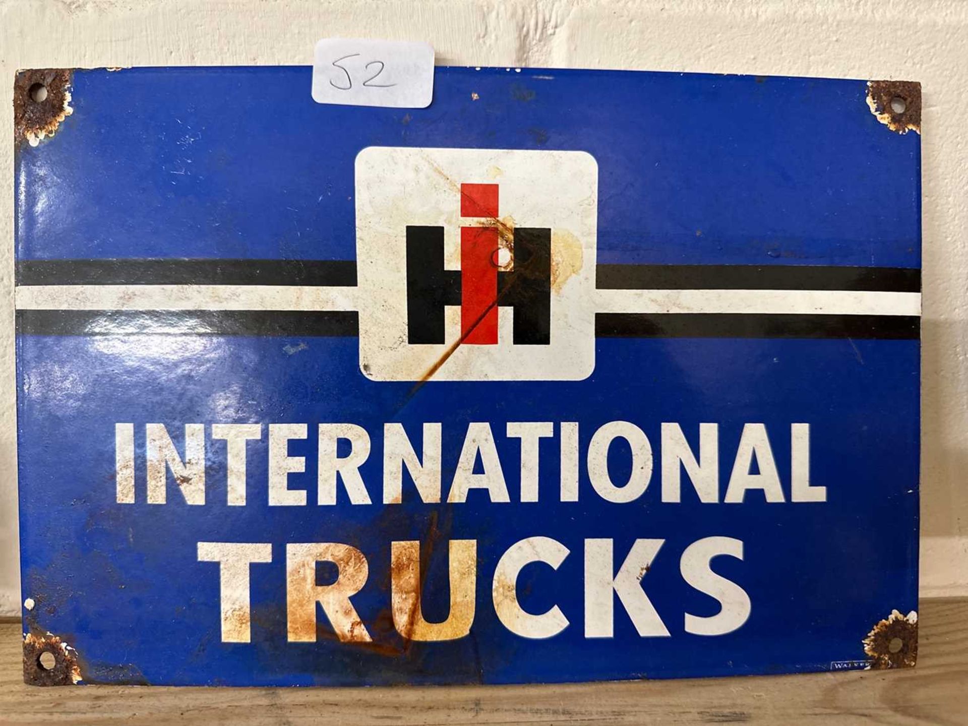 A reproduction enamel sign for "International Trucks"