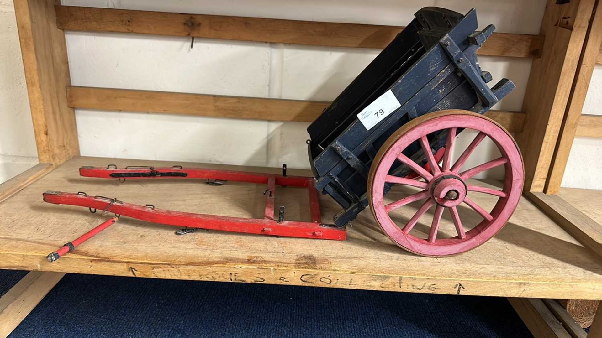 A scratch built model of a single axle cart painted in red and blue, approx 50cm long