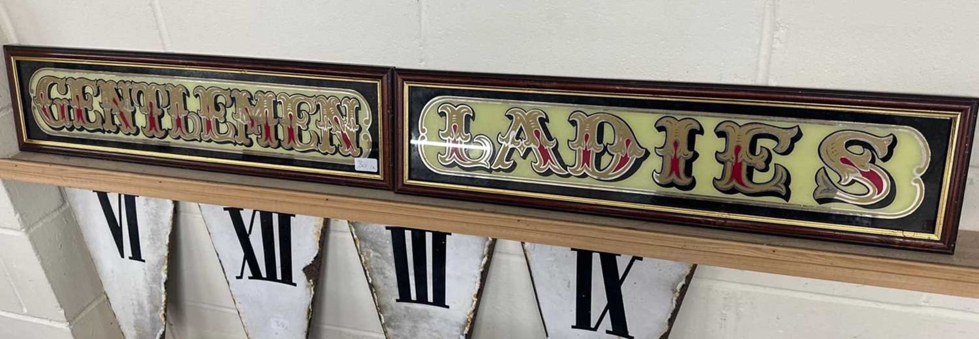 Two mirrored pub signs "Gentlemen" and "Ladies", both framed