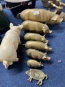 Six graduated brass model pigs together with a further painted iron model pig and a similar