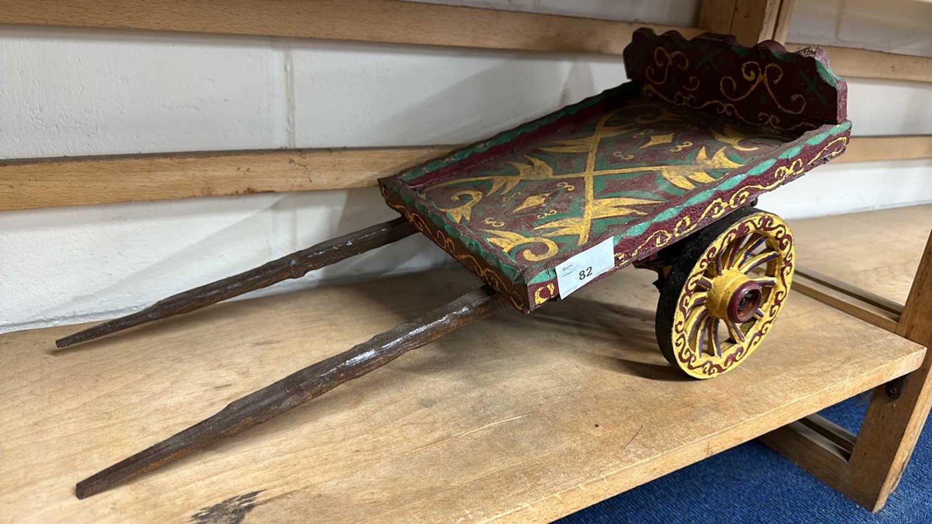 A scratch built model of a single axle flat topped cart with painted decoration, 48cm long