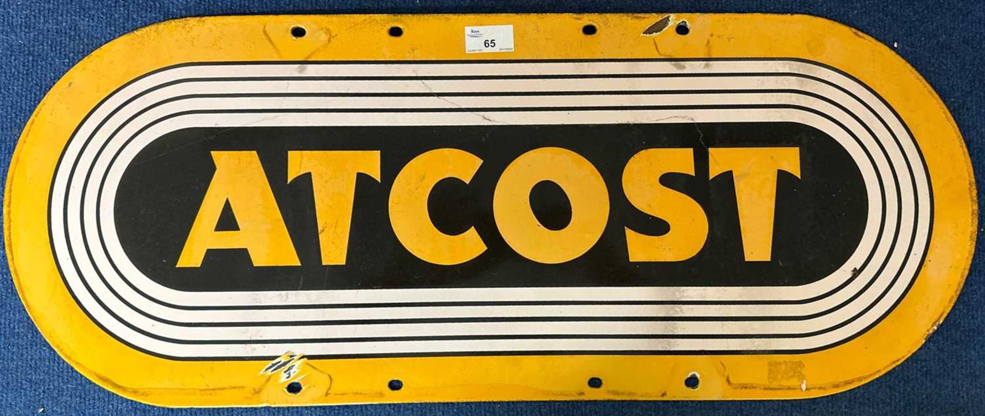 An oval enamel sign marked At Cost, 66cm wide