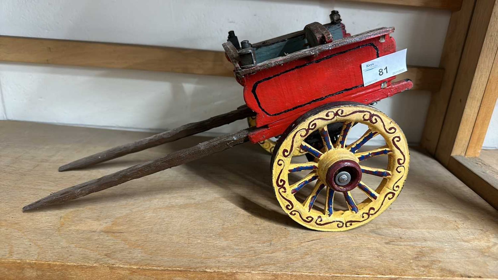 A scratch built model of a small single axle cart, painted in red and yellow, approx 34cm long