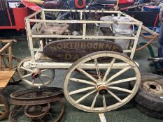 Vintage wood framed three wheel dairy cart bearing plaques for North Bourne Dairy containing a range