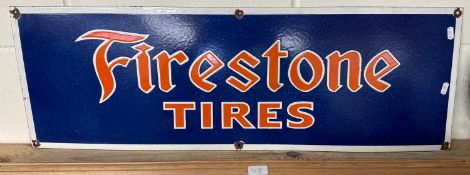 A reproduction metal sign for "Firestone Tires"