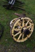 A pair of small yellow painted wood framed wheels with iron mounts and a further single wheel (3)