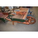 Wood framed wheelbarrow with orange and green painted body