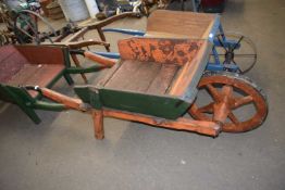Wood framed wheelbarrow with orange and green painted body