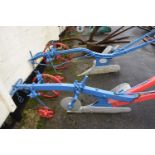 A large iron and wood framed horse drawn single furrow plough, painted in red and blue