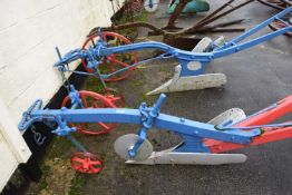 A large iron and wood framed horse drawn single furrow plough, painted in red and blue