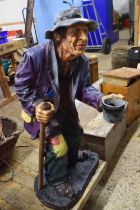 Glass fibre figure of a beggar