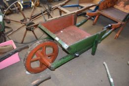 Vintage green painted wooden wheelbarrow with iron mounted wheel