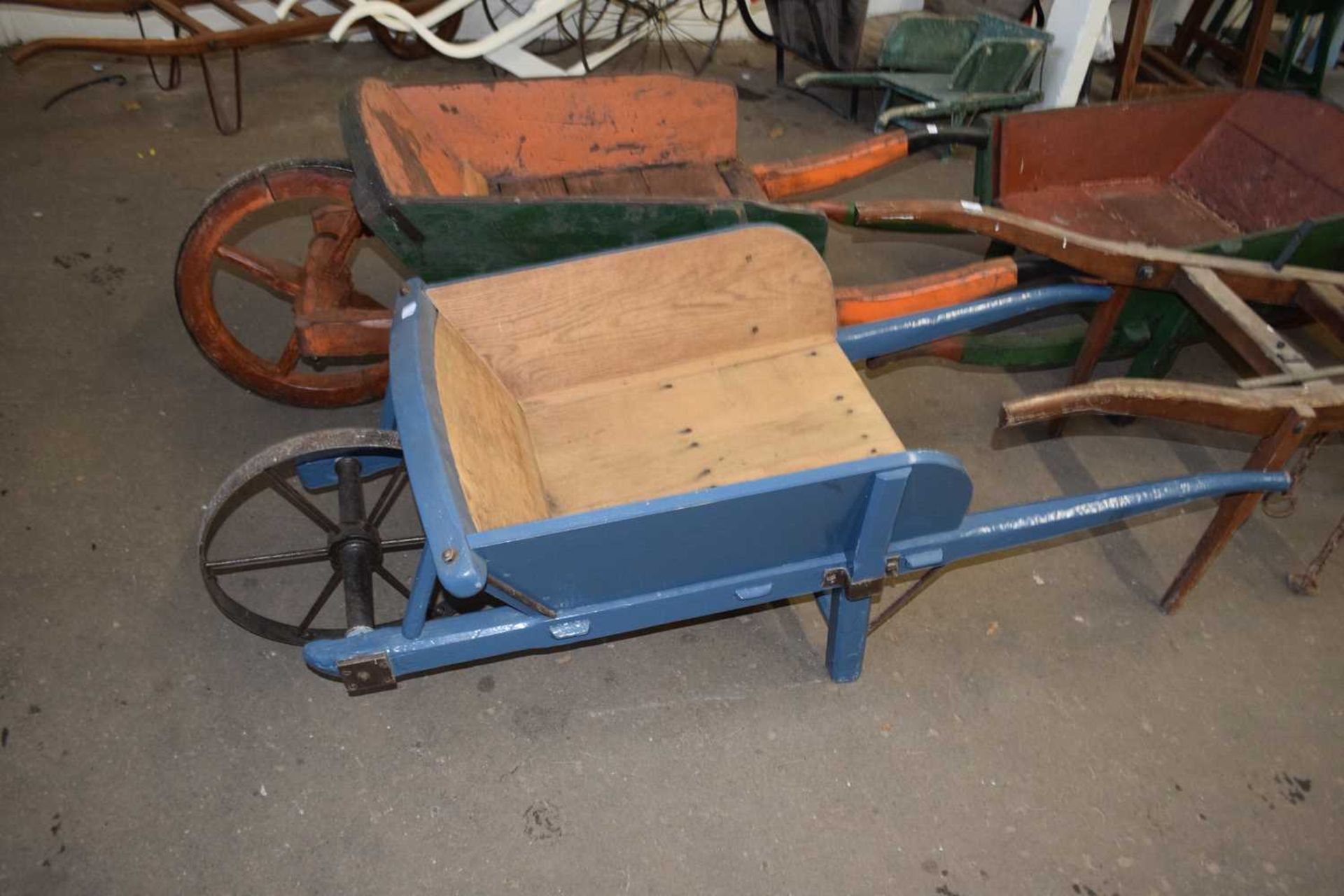 Wooden wheelbarrow with blue painted body and solid iron wheel