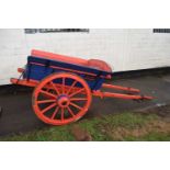 A single axle farm cart with red and blue painted body