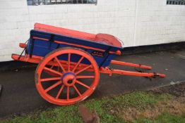 A single axle farm cart with red and blue painted body