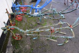 A horse drawn iron framed cultivator with blue and red painted body, for restoration