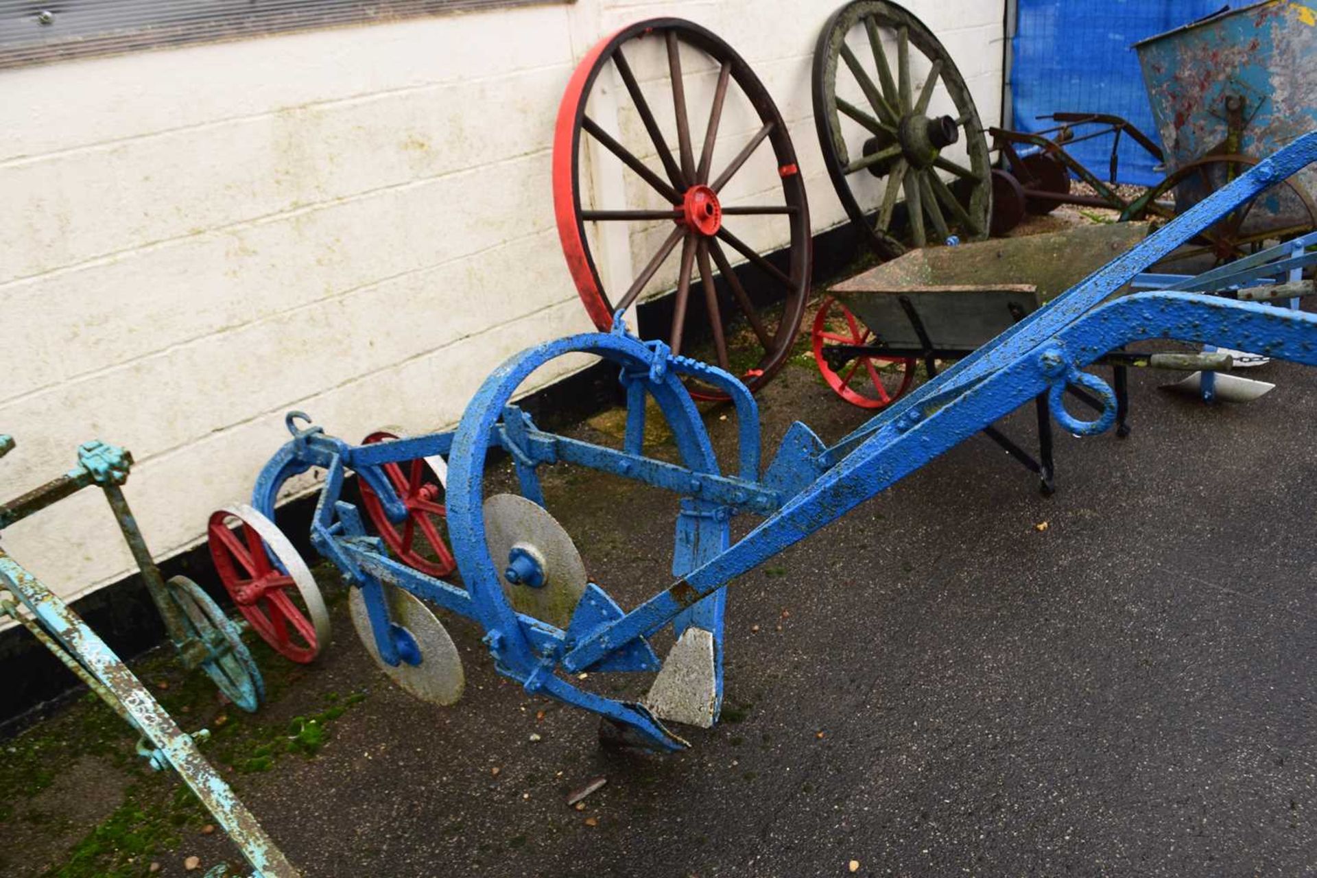 A horse drawn iron framed cultivator with discs, the body painted blue