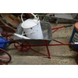 Vintage galvanised child's wheelbarrow and a painted watering can
