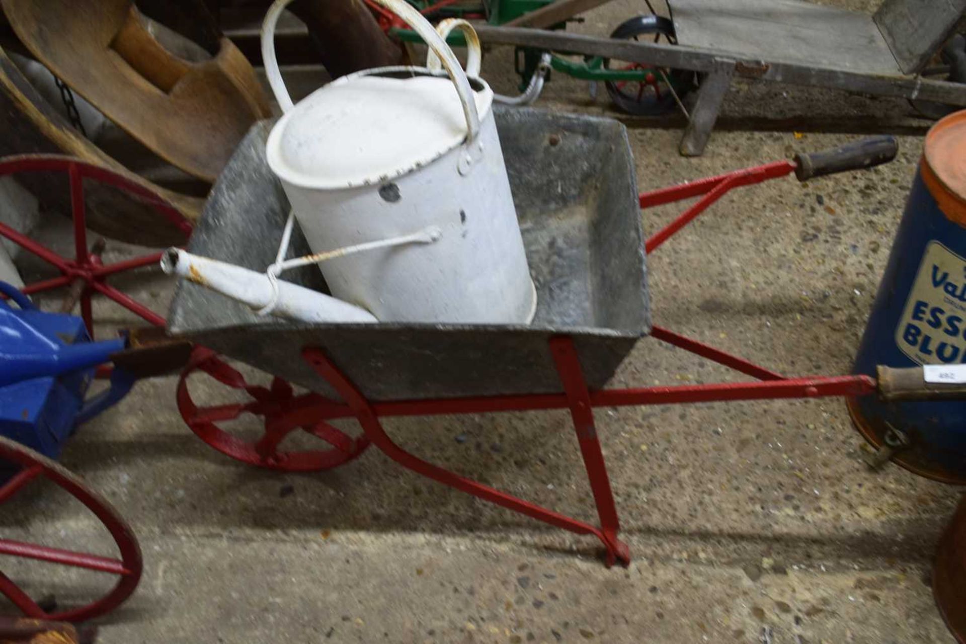 Vintage galvanised child's wheelbarrow and a painted watering can