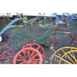 A single furrow cast iron framed horse drawn plough with green painted frame