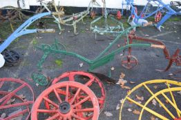 A single furrow cast iron framed horse drawn plough with green painted frame