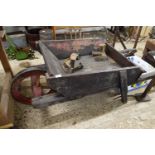 Wooden wheelbarrow with iron mounted wheel