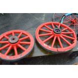 Two red painted wooden cartwheels