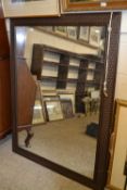 A large modern wall mirror in woven effect frame