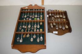 Two wall display racks of crested spoons