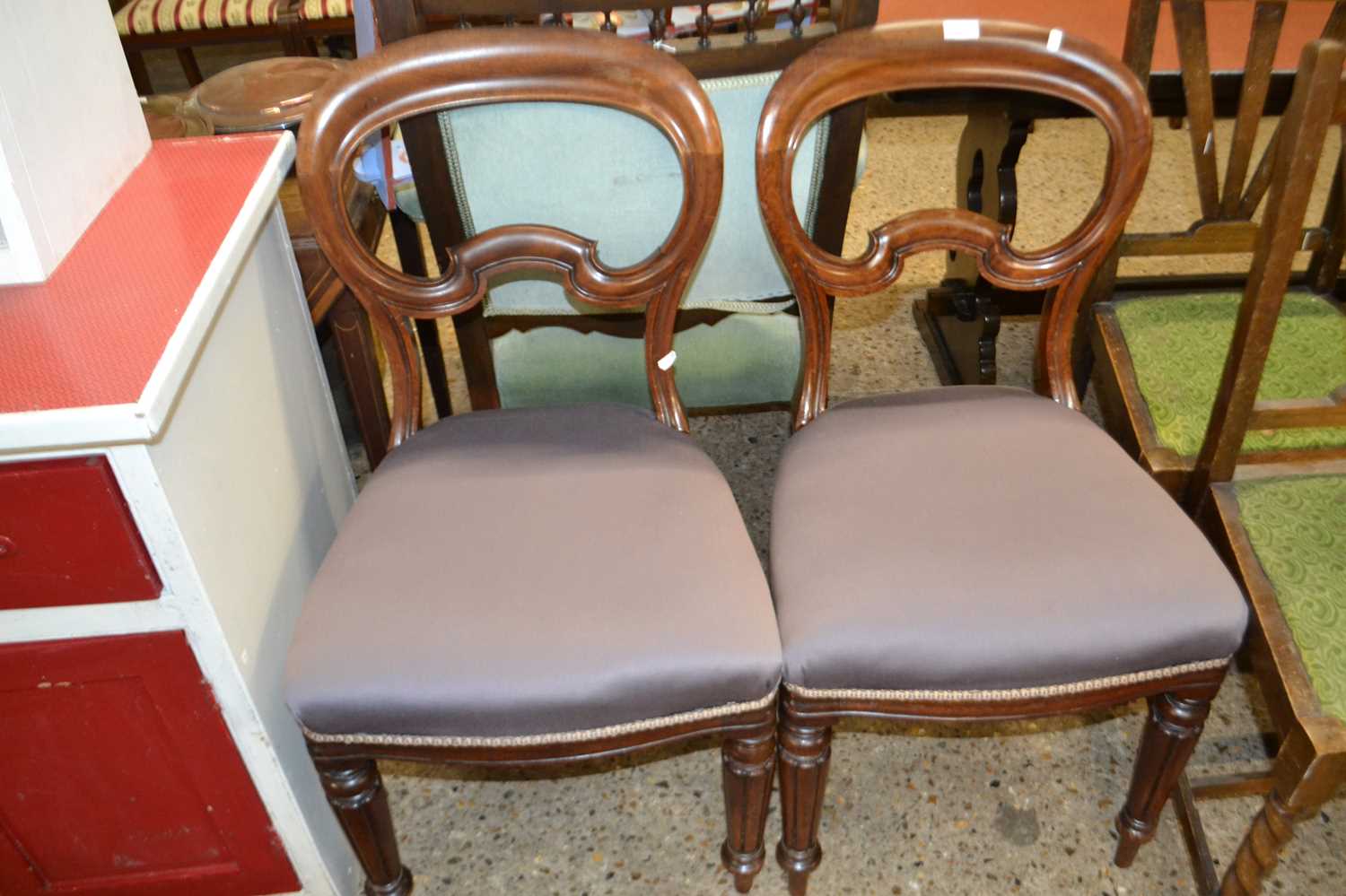 A pair of Victorian balloon back dining chairs