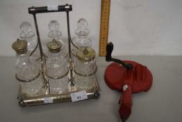 A silver plated six bottle cruet stand together with a vintage bean slicer