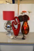 Modern chrome based table lamp, a further abstract ceramic table lamp and a vase of fake flowers (