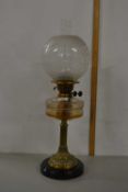 An oil lamp with frosted glass shade, clear font and brass base
