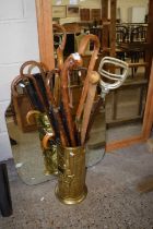 Brass stick stand with various sticks and umbrellas