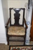 An 18th Century oak elbow chair with solid seat and stretcher base, several repairs and