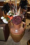 A large pottery urn and a quantity of artificial flowers