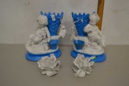 A pair of continental porcelain models of children with baskets of grapes together with two