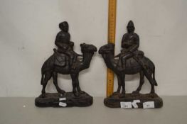 Pair of iron door stops formed as figures on camels
