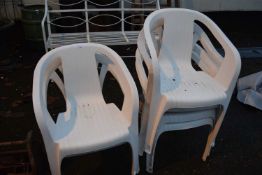 Six white plastic garden chairs