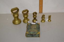 A group of five small brass weights together with a small brass book marked Codex