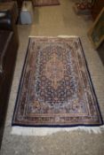 A modern Middle Eastern wool floor rug with large central blue lozenge