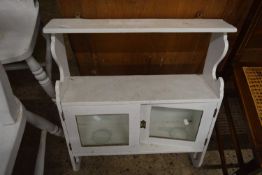 A white painted wall shelf with glazed cupboard