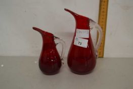 Two red glass jugs