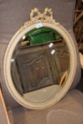 A cream and gilt decorated oval wall mirror