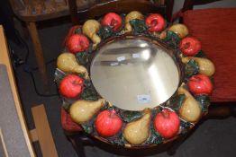 A fruit decorated round wall mirror