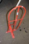 A red painted wall mounted saddle stand